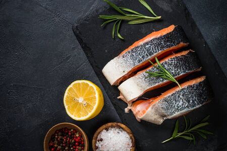 Raw salmon steak on black top view.の写真素材