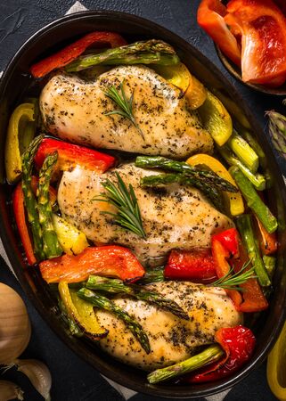 Baked chicken fillet with vegetables. Healthy food, keto diet, one pot dish. Top view at dark table.の写真素材