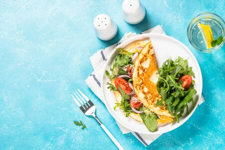 Omelette with green leaves top view.