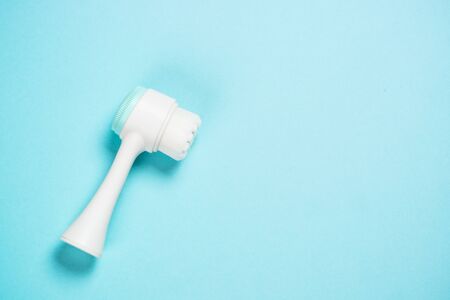 Face massage brush on blue background.の写真素材