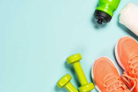 Fitness equipment at blue background top view.