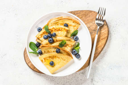 Crepes with blueberries at white table.の写真素材