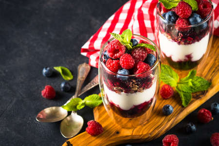 Parfait with granola, jam and fresh berries in the glass jar.の写真素材