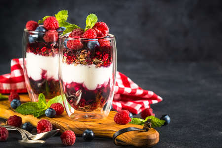 Parfait with granola, jam and fresh berries in the glass jar.の写真素材