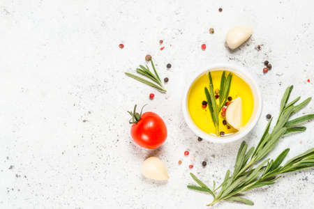 Herbs, spices and vegetables at white kitchen table.の写真素材
