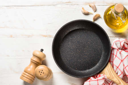 Frying pan or skillet on white wooden table.の写真素材