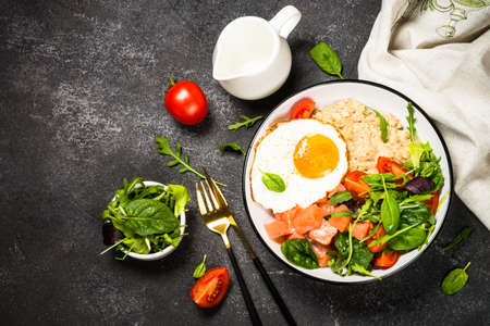 Savory breakfast with oatmeal, salmon and salad.の写真素材