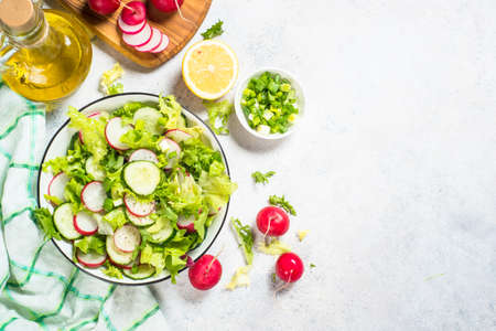 Green salad with fresh leaves, radish, cucumber and ollive oil.の写真素材
