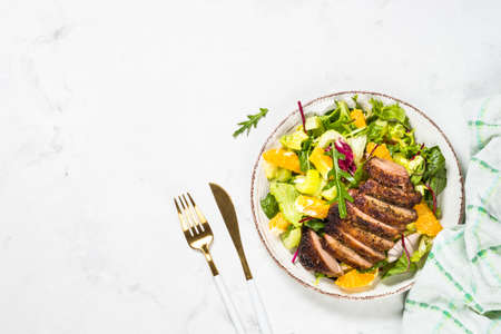 Salad with baked duck, green salad mix and oranges.の写真素材