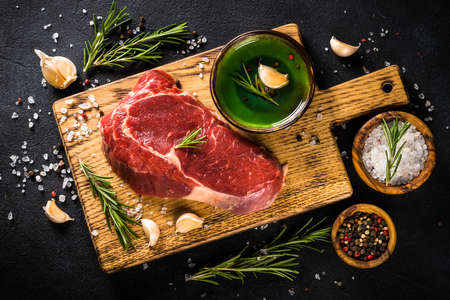 Raw beef steak with herbs at black.の写真素材