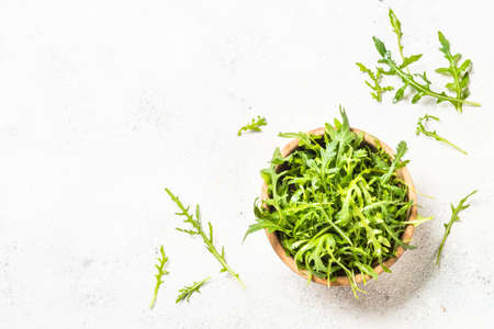 Arugula fresh green leaves at white table.の写真素材