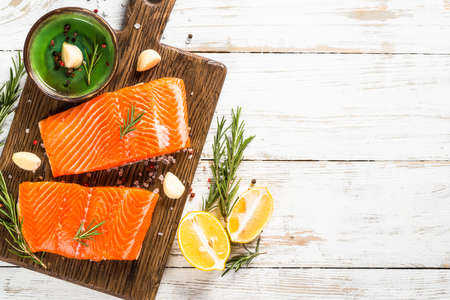 Salmon fish with ingredients at white table.の写真素材
