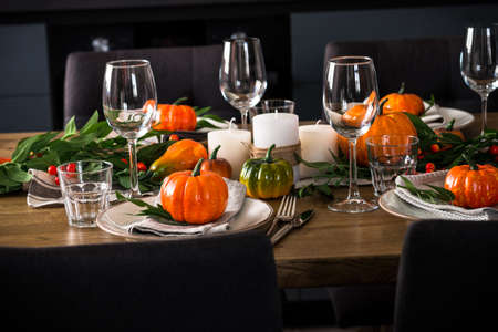 Autumn table setting with plate, pumpkin and candles.の写真素材