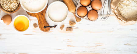 Baking ingredients at white wooden table.