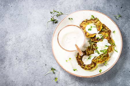 Zucchini pancakes with spinach, hepbs and parmesan cheese, served with sour cream.の写真素材