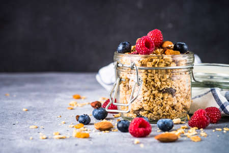Granola with fresh berries in the glass jar.