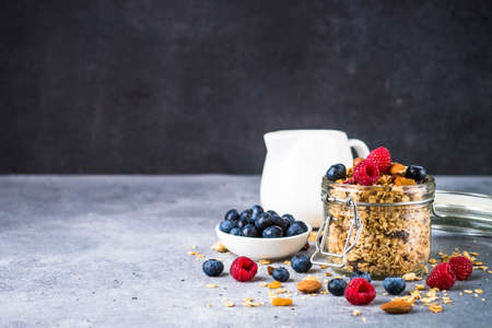 Granola with fresh berries in the glass jar.の写真素材