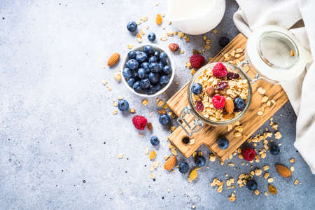 Granola with fresh berries in the glass jar.