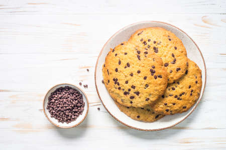Giant cookies with chocolate chips at white table.の写真素材