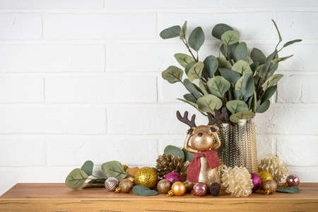 Christmas decorations indoor - Shelf with candles, eucalyptus branches and golden decor.の写真素材