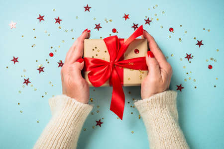 Christmas present box with red ribbon at blue.