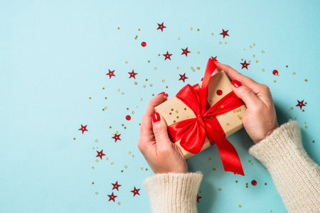 Christmas present box with red ribbon at blue.の写真素材