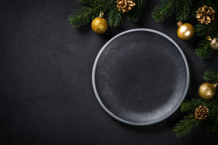 Christmas table setting with holiday decorations at black background.の写真素材