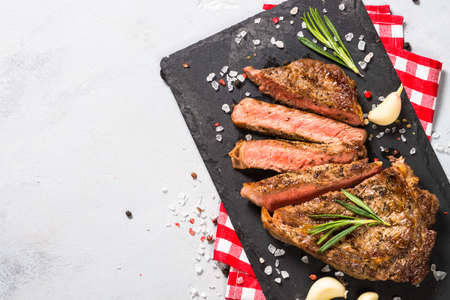 Grilled beef steak on black serving board.の写真素材