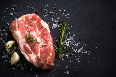 Fresh steak with herbs and spices at black background.の写真素材