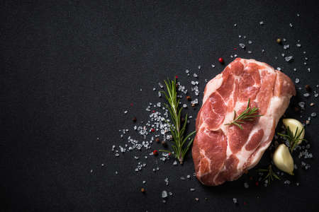 Fresh steak with herbs and spices at black background.の写真素材