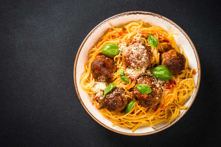 Pasta with Meatballs in tomato sauce at black background.の写真素材