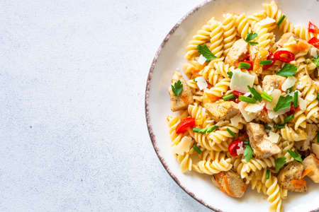 Italian pasta with tomato sauce, basil and parmesan cheese on white table.の写真素材
