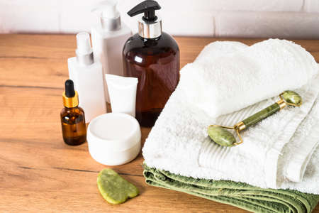 Bottle of soap and stack of towels in white bathroom.の写真素材