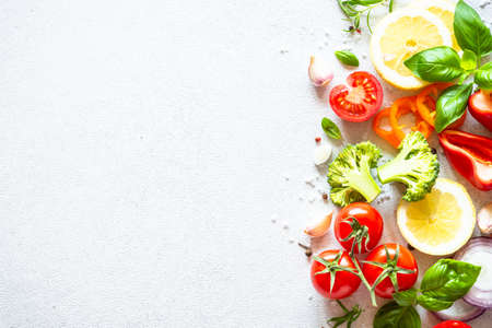 Fresh vegetables, herbs and spices on white background. Ingredients for cooking. Top view with copy...