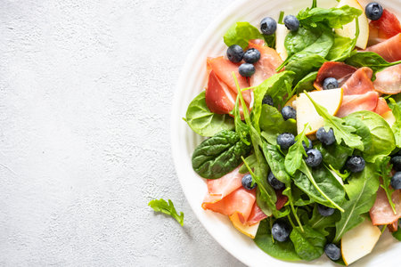 Healthy salad with spinach, jamon, pear and blueberry.の写真素材