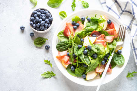 Healthy salad with spinach, jamon, pear and blueberry.の写真素材