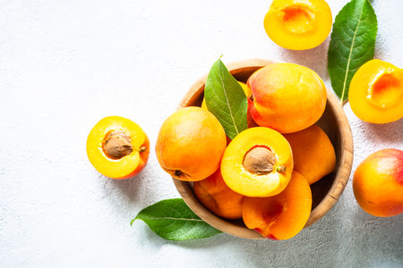 Fresh apricots with green leaves at white.の写真素材