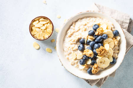 Oatmeal porrige in craft bowl at white background.の写真素材