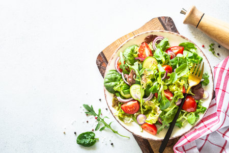 Green salad, Fresh salad leaves and vegetables in white plate.の写真素材
