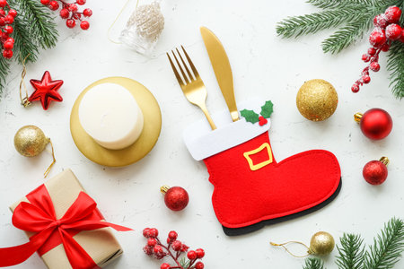 Christmas table setting. White plate, cutlery, red and golden decorations.の写真素材