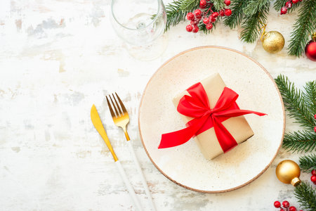 Christmas table setting with plate, cutlery and christmas decorations on white background.の写真素材