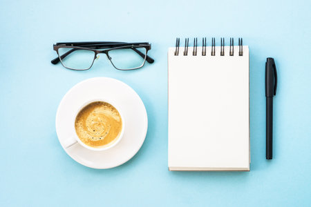 Office table desk with laptop, notepad, pen and cup of coffee.の写真素材