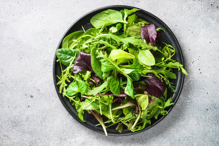 Salad from green leaves and vegetables on white.の写真素材