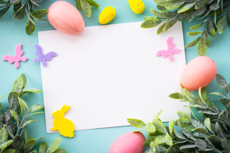 Easter background with Eggs, rabbit and spring flowers at blue background.