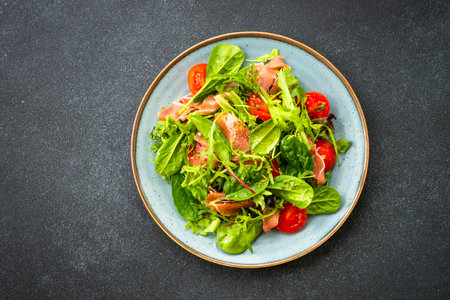 Healthy salad with green leaves, tomatoes and jamon.の写真素材