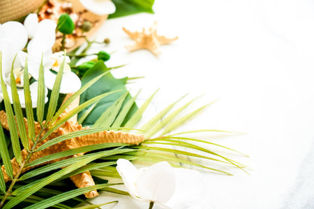 Palm leaves, hat and tropical flowers on white.の写真素材