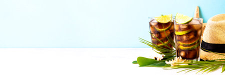 Cuba Libre alcoholic cocktail, iced drink with palm leaves and sea shells.の写真素材