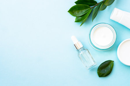 Natural cosmetic, cream jar with green leaves on blue.の写真素材