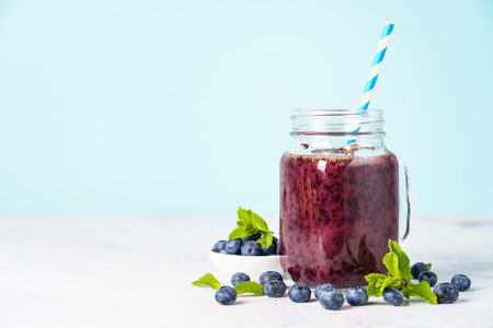 Blueberry smoothie with fresh berries at blue background.の写真素材