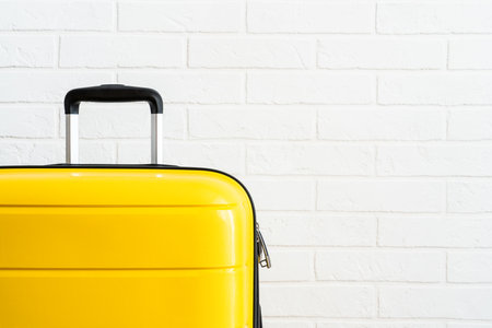 Yellow baggage near white brick wall.の写真素材